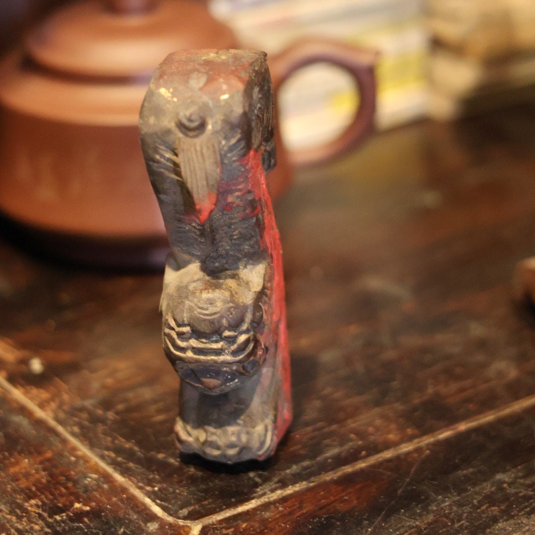 Front view of the hand-carved 1950s wooden lion (or Foo Dog) figurine, featuring vibrant red lacquer. This figure may have adorned a traditional Chinese beam as a guardian, showcasing its significance and craftsmanship.