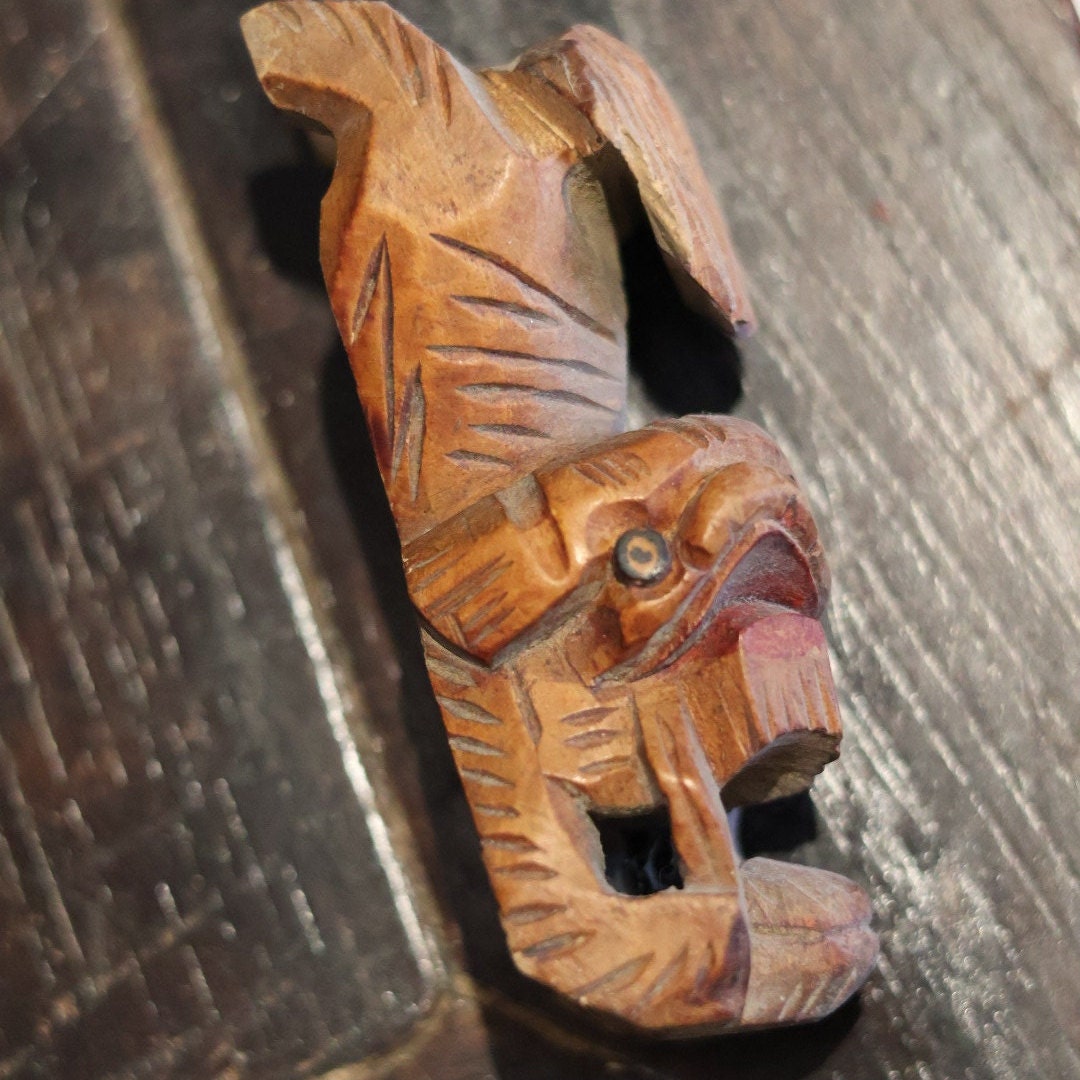 This close-up of the left side of the figurine’s head reveals detailed carving, especially around the eyes and mane. Each feature of this vintage 1950s wooden lion, often known as a Foo Dog, is meticulously crafted, embodying masterful artistry and making it a prized collectible.