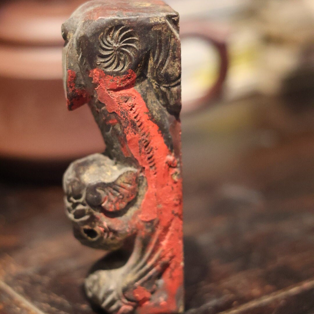 Left side view of the wooden lion figurine with traces of red lacquer, carved in the 1950s. This unique piece was possibly an ornament on a traditional Chinese beam, adding cultural depth and mystique.