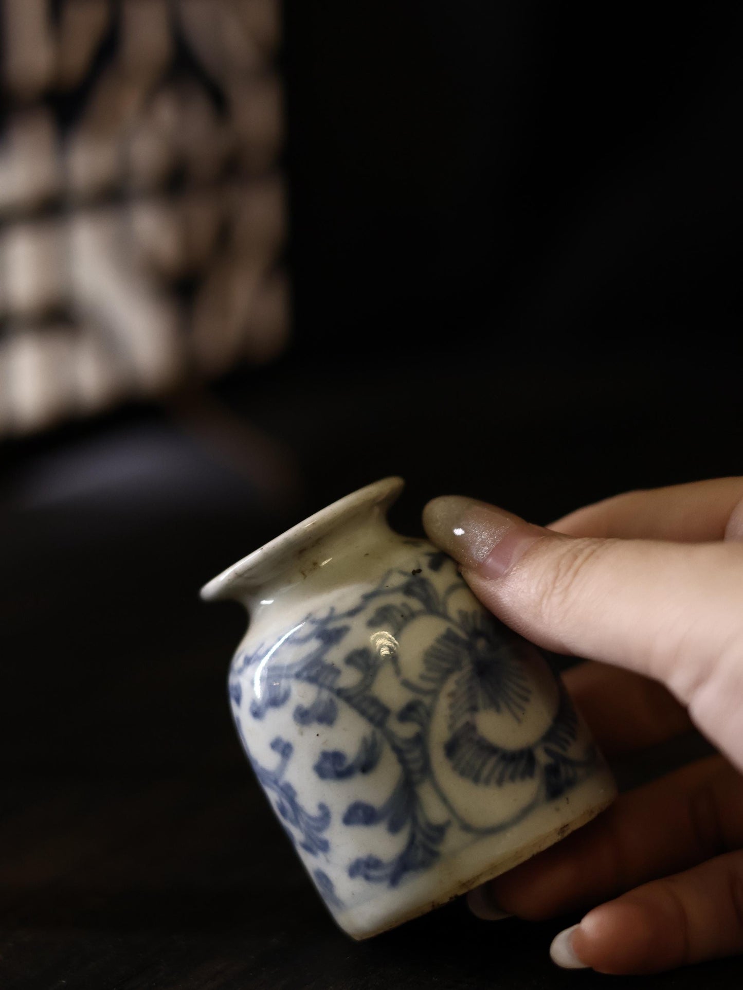 Captured from a close-up angle, this Qing Dynasty porcelain vase highlights the detailed brushwork of the blue floral motifs against a white background. This rare antique is perfect for collectors who appreciate the history and artistry of Chinese blue and white porcelain.