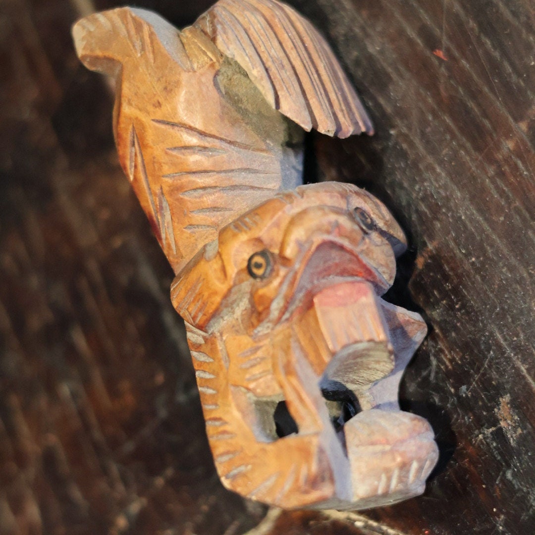 A focused close-up on the left side of this antique Foo Dog figurine’s head, capturing the intricate carvings around the face and mane. This 1950s wooden ornament is a testament to traditional craftsmanship, ideal for enthusiasts of unique, historical artifacts.
